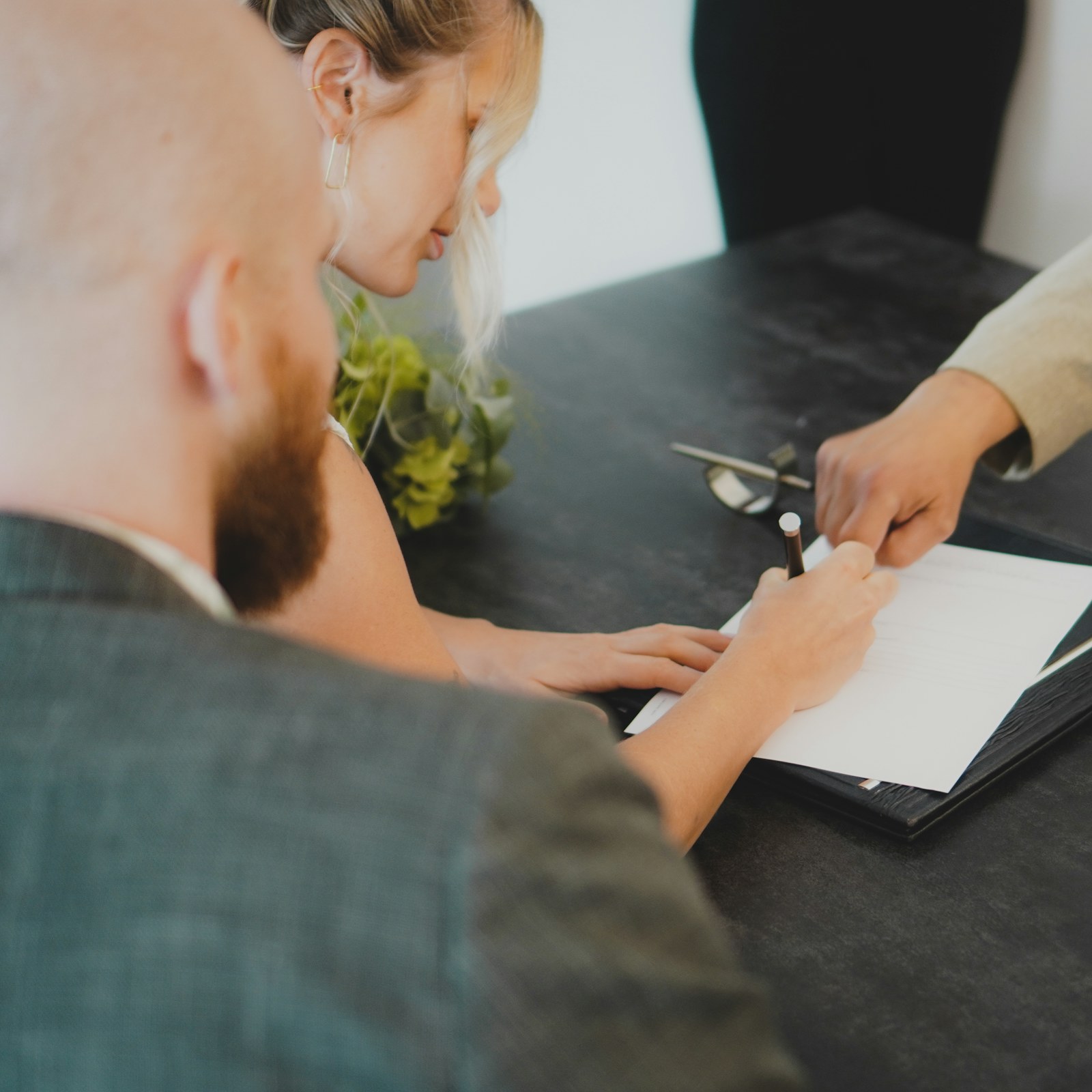 Couple signing their mortgage application with a loan officer