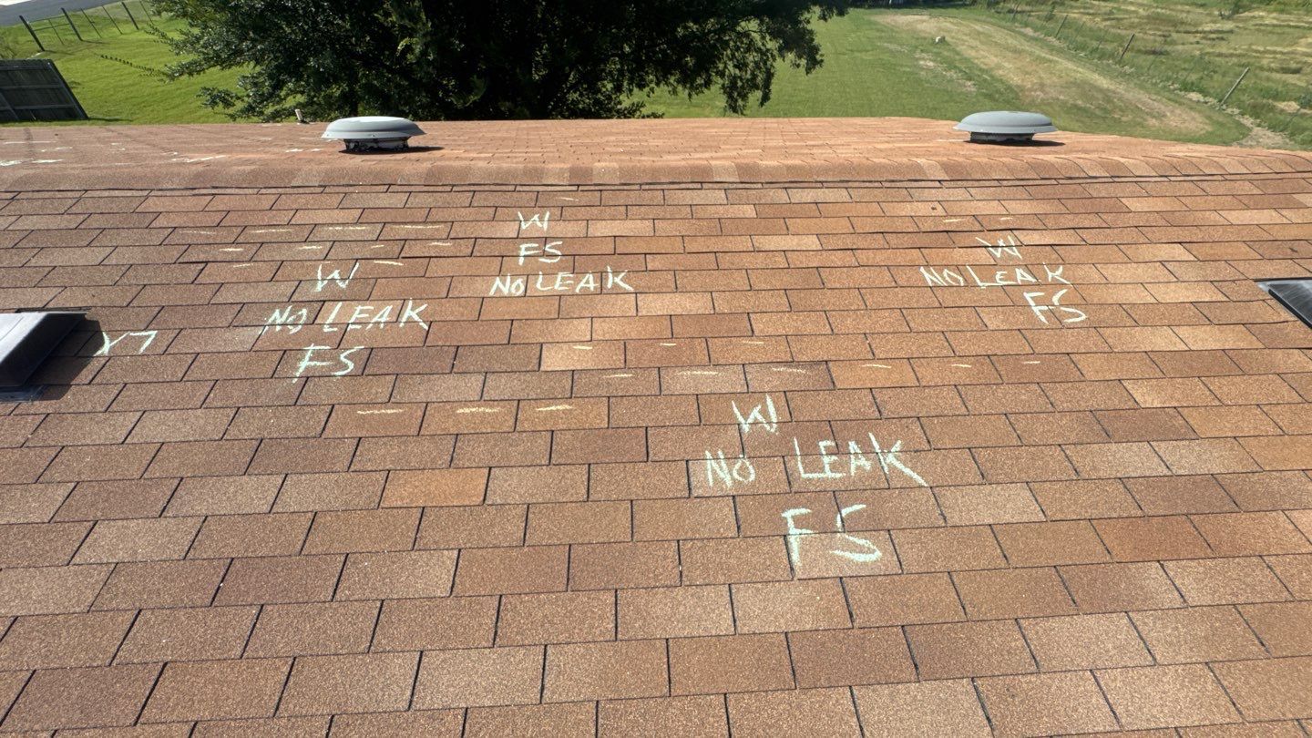 Wind damage marked in chalk on shingles during a roof inspection