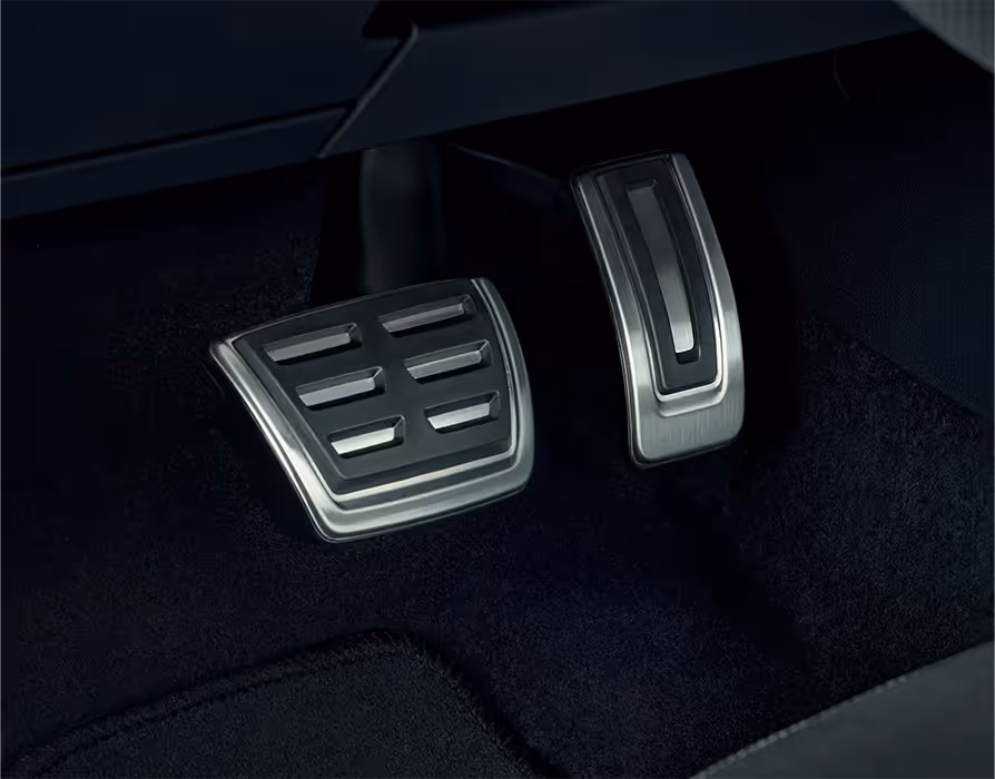 Nahaufnahme der sportlichen Edelstahlpedalerie im Fußraum des Škoda Fabia 130. Die Pedale für Gas und Bremse zeichnen sich durch ihre Metalloptik in Kombination mit rutschfesten schwarzen Gummielementen aus. Der Kontrast zum dunklen Bodenteppich hebt die Pedalerie optisch hervor.