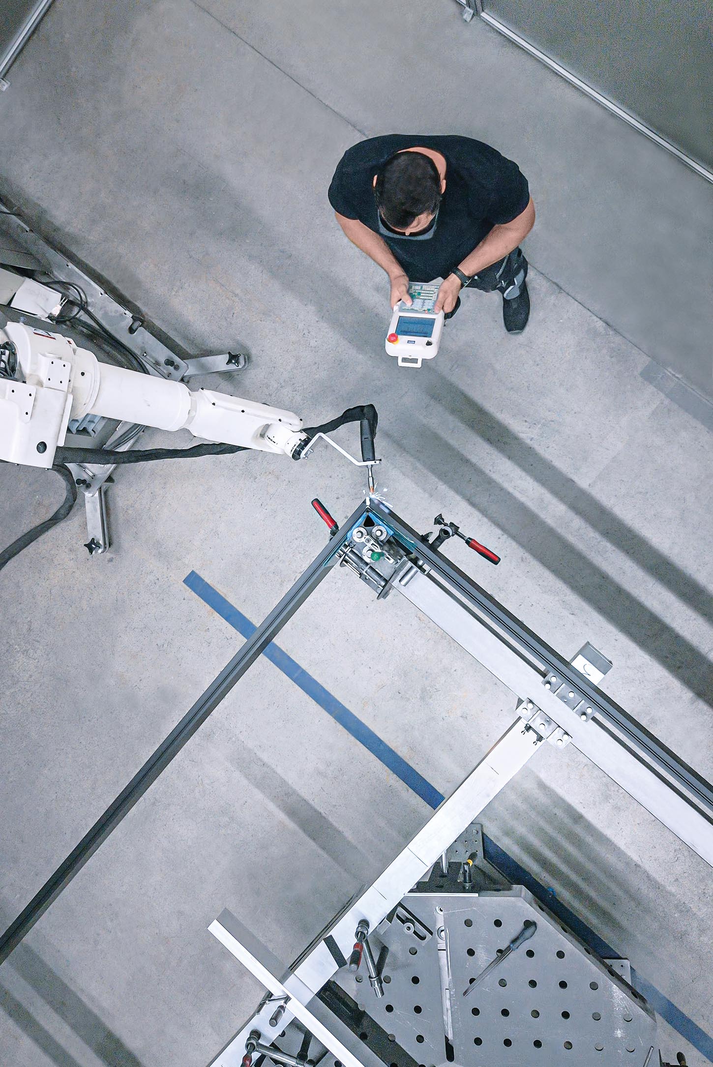 Industrieanlage mit Roboterarm und Steuerungstechniker der Abele Automation