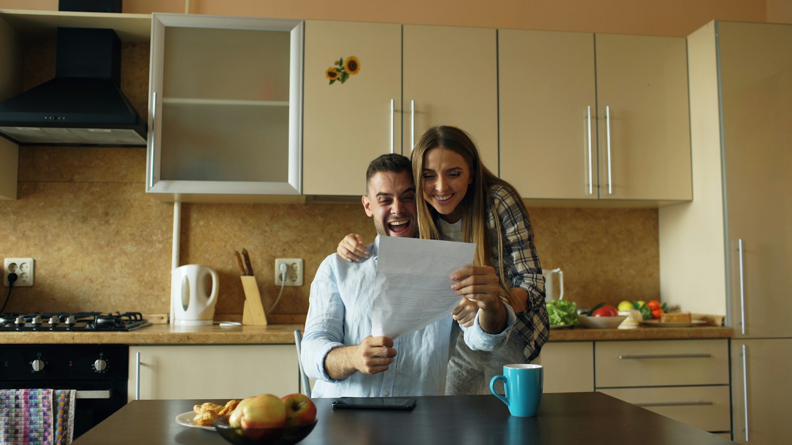 Couple reviewing refinance paperwork at the kitchen table