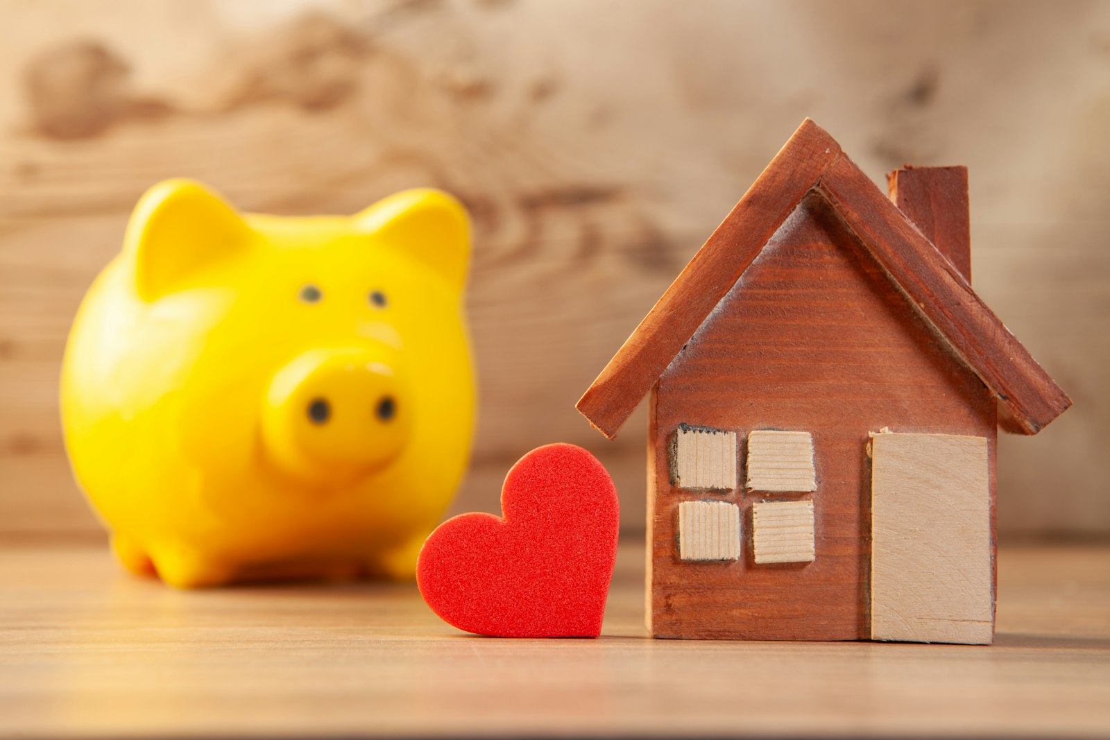 Piggy bank next to a small wooden house