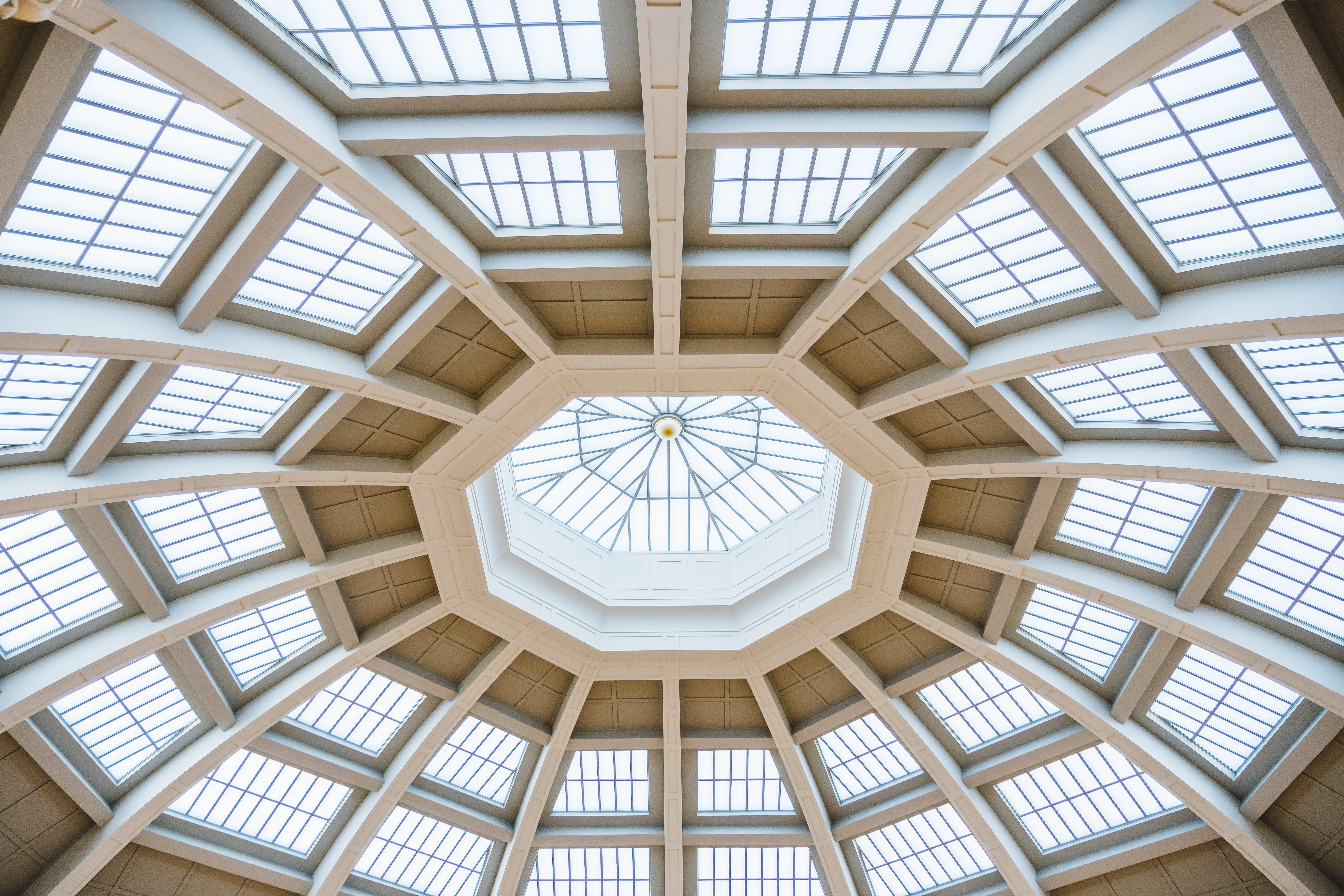 Intricate octagonal glass skylight ceiling with multiple window panes and supporting beams.