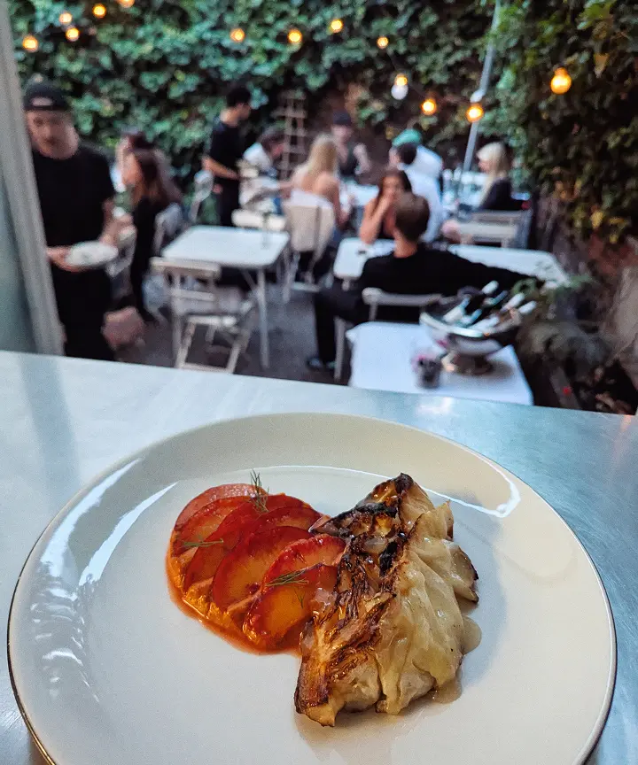 Gegrillte Fischfilets mit tomatenscheiben auf weißem Teller in einem Restaurant.