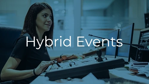 Broadcast engineer managing AV production backstage at a hybrid corporate meeting