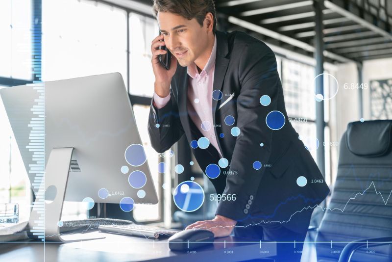 Businessman in suit using smart phone to optimize trading strategy at corporate finance fund forex chart hologram over modern panoramic office background