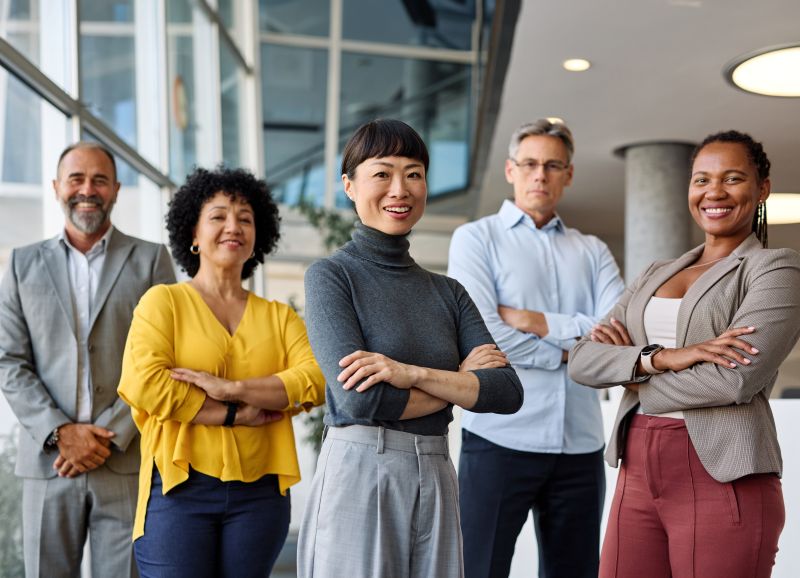 Five business professionals standing together in an office