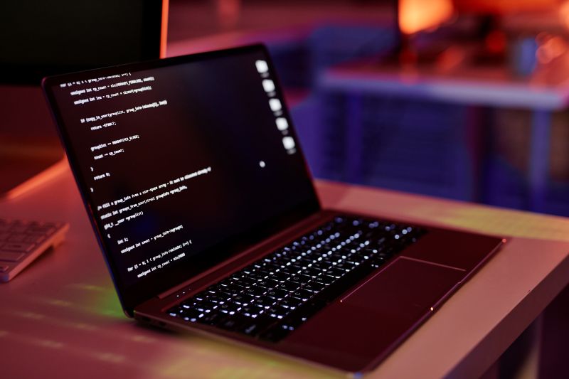 Laptop displaying code in a workplace