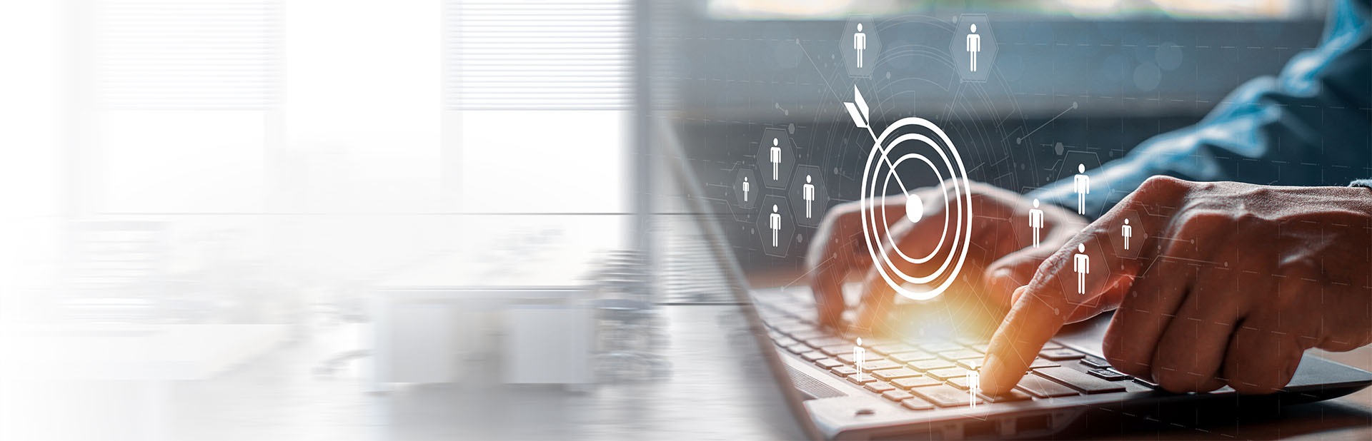 Close-up of hands typing on a laptop with a digital target icon and user silhouettes overlaid, representing audience targeting or customer segmentation.