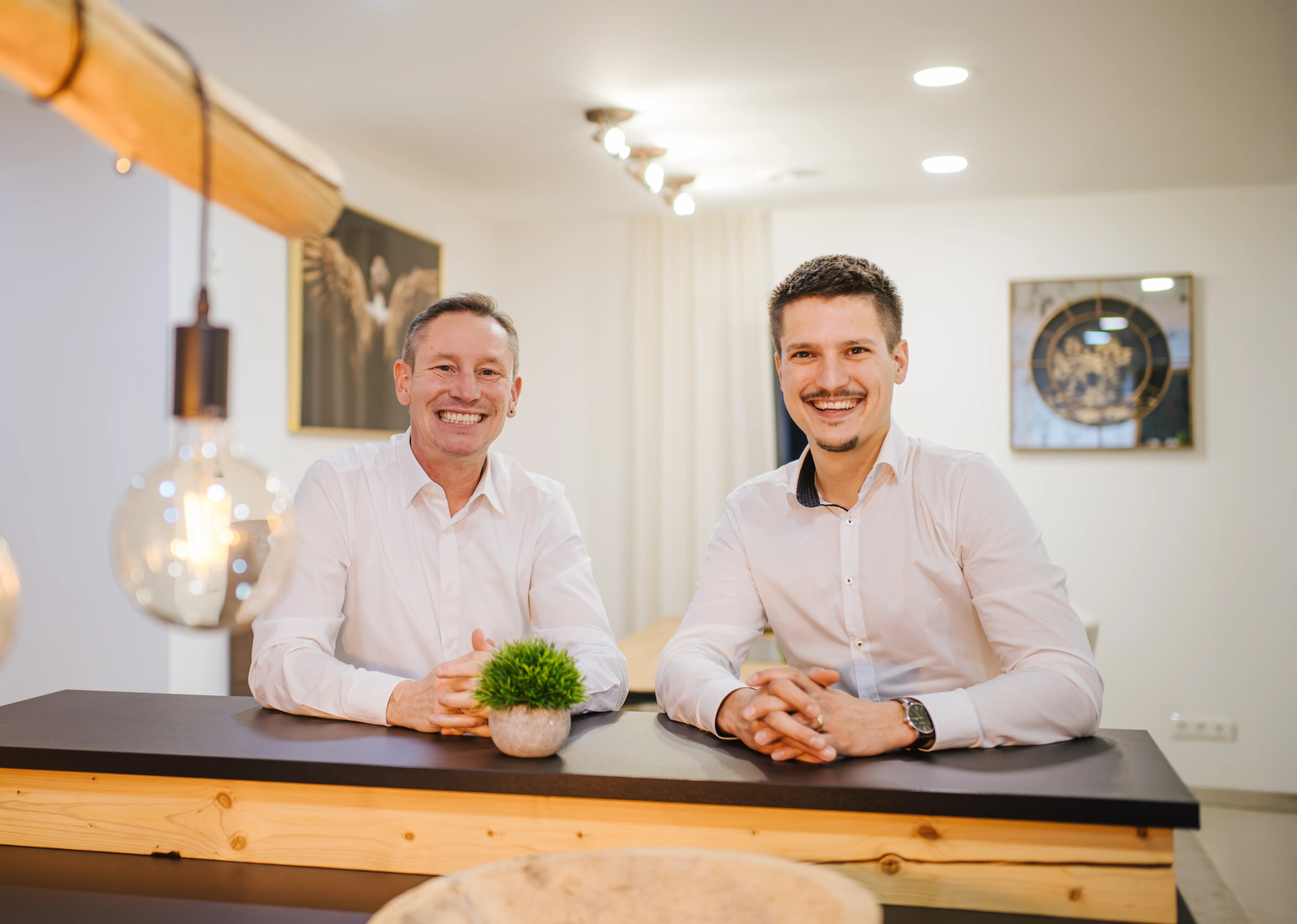 Michael Zeiher und Nicolaj Pietsch am Lächeln an einer Küchentheke.