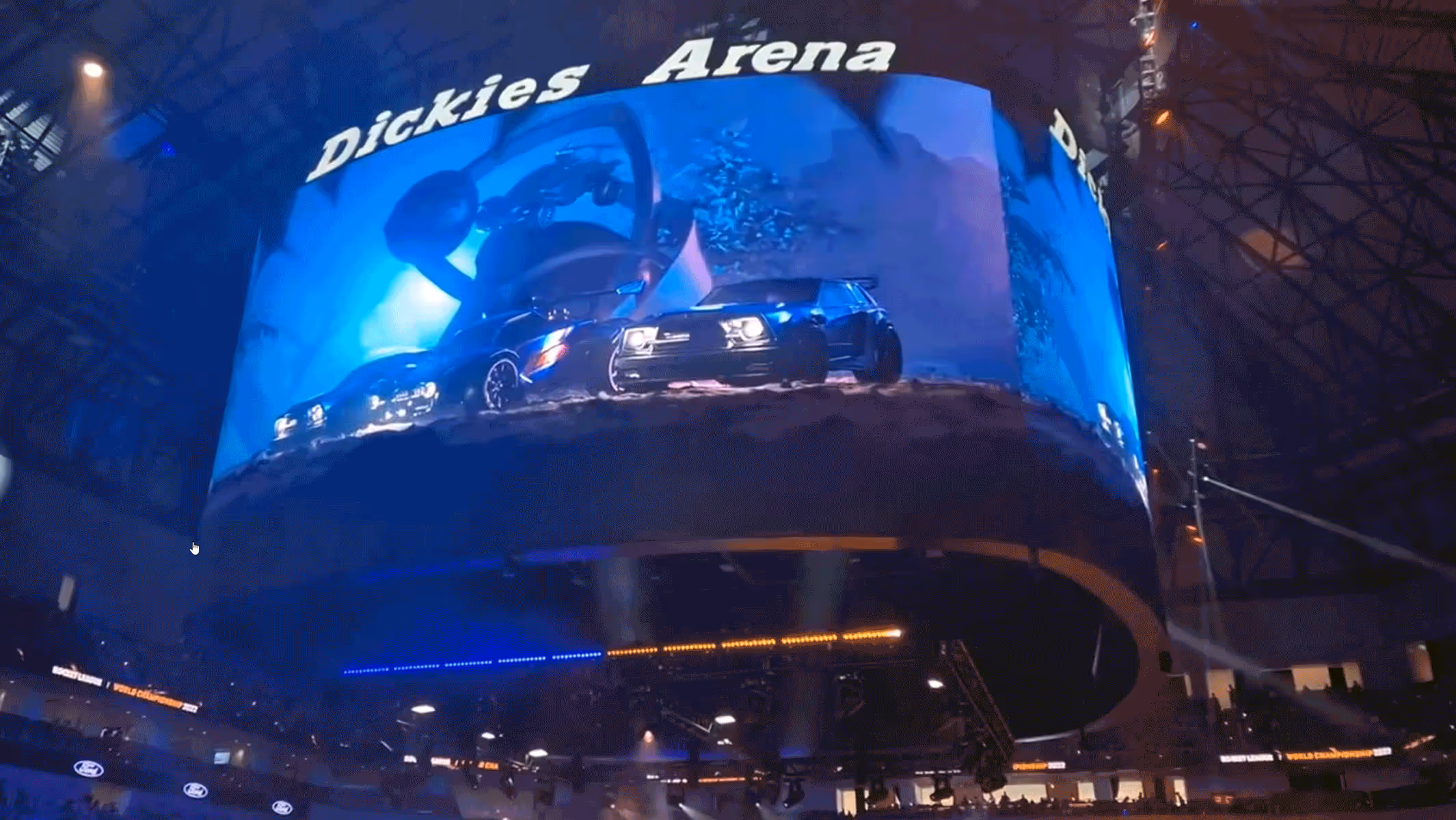 Large curved arena screen displaying three illuminated cars with 'Dickies Arena' text above.