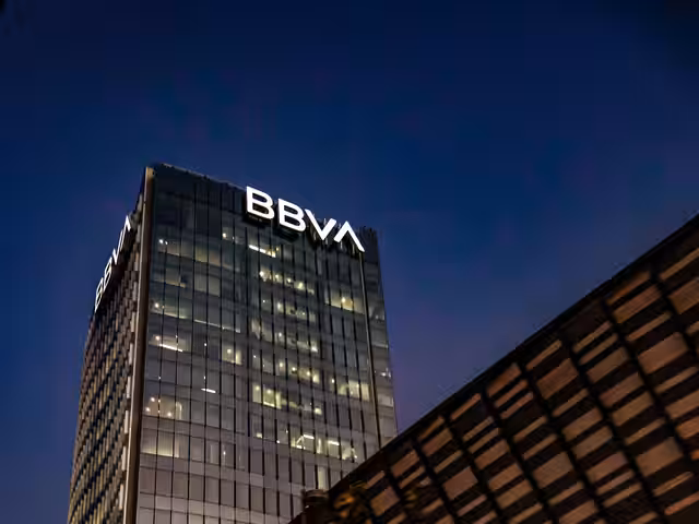 Torre de oficinas bancarias al atardecer con iluminación cálida en exterior urbano