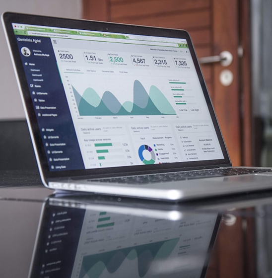 Laptop displaying a data analytics dashboard with charts, performance metrics, and financial statistics.
