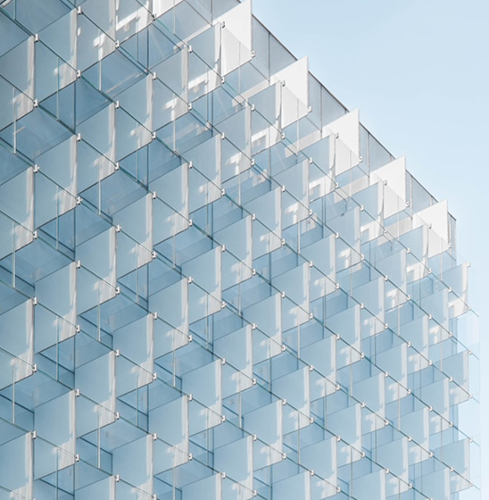 Modern building facade made of geometric glass panels, representing contemporary architecture.