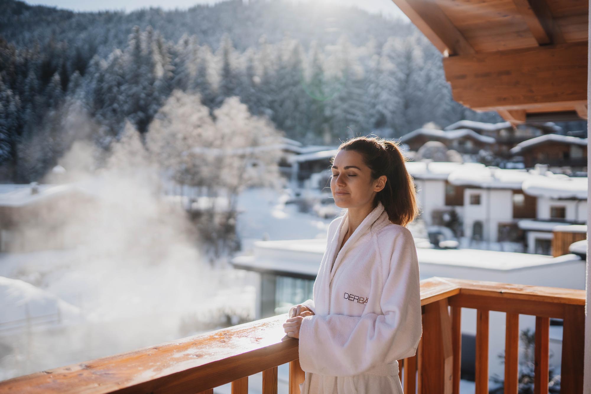 guest enjoying mountain view from hotel balcony with steam