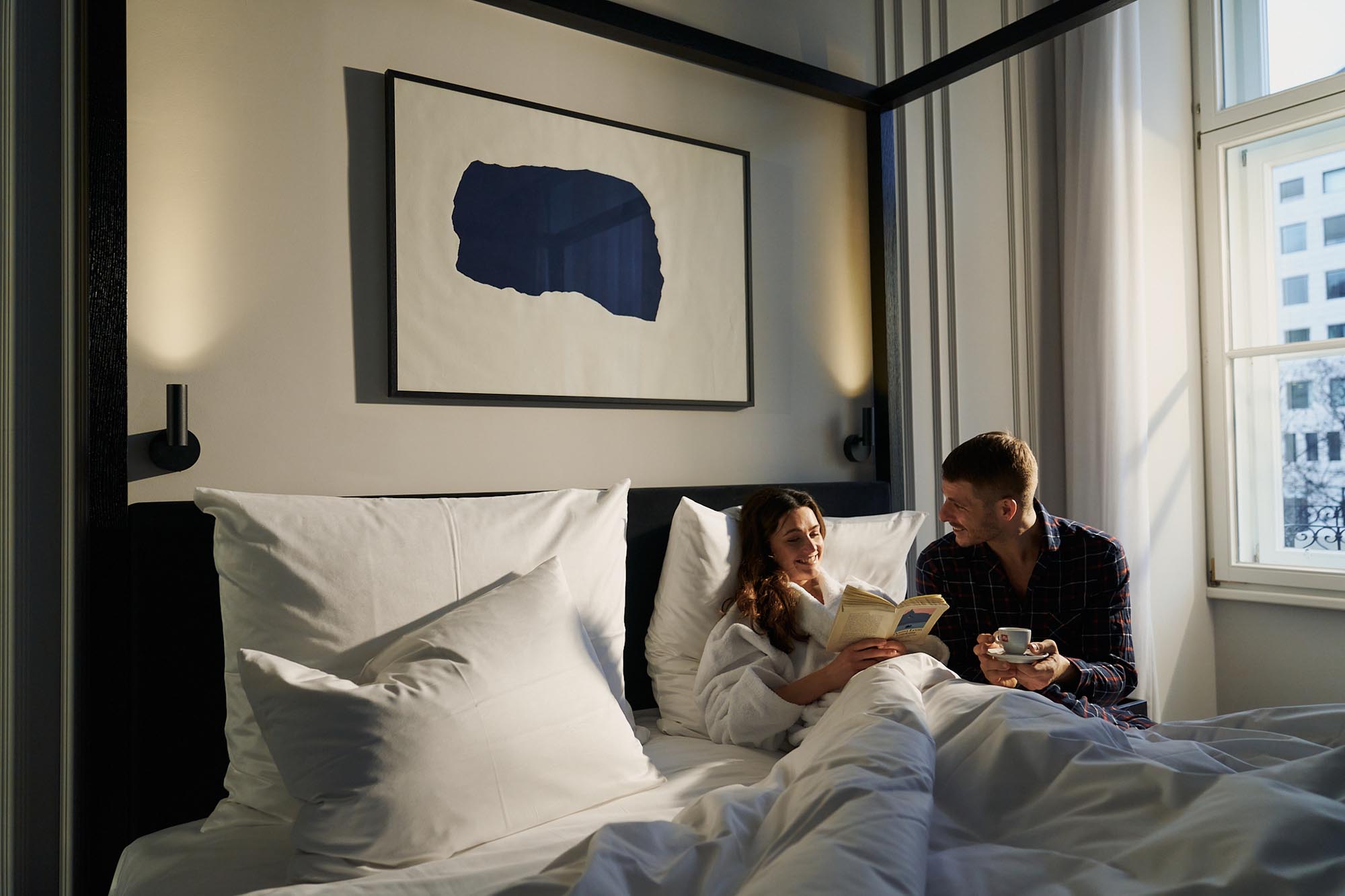 guests relaxing in bed in boutique hotel room
