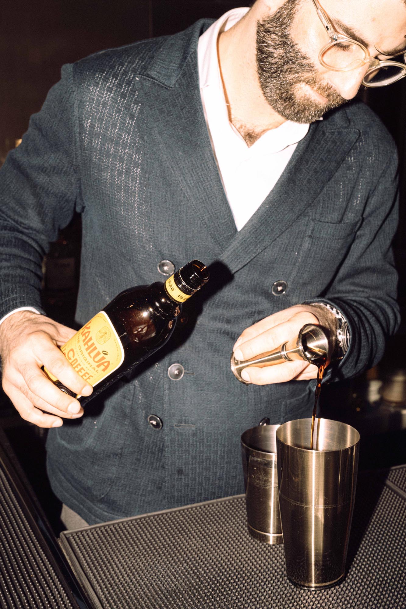 bartender pouring drink in warm bar setting - flash look