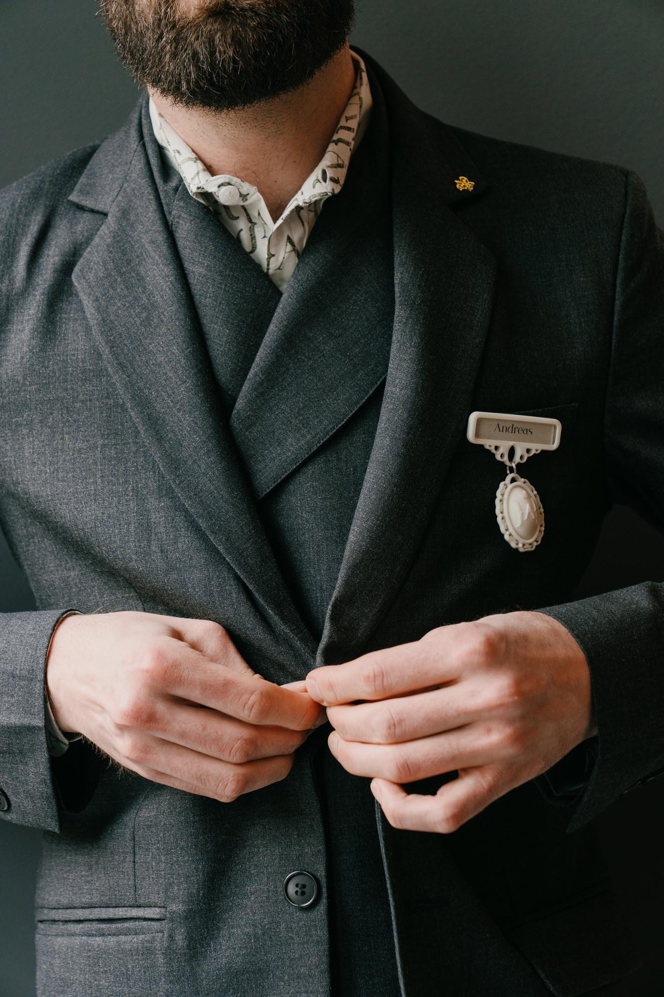 hotel staff adjusting uniform detail in soft light