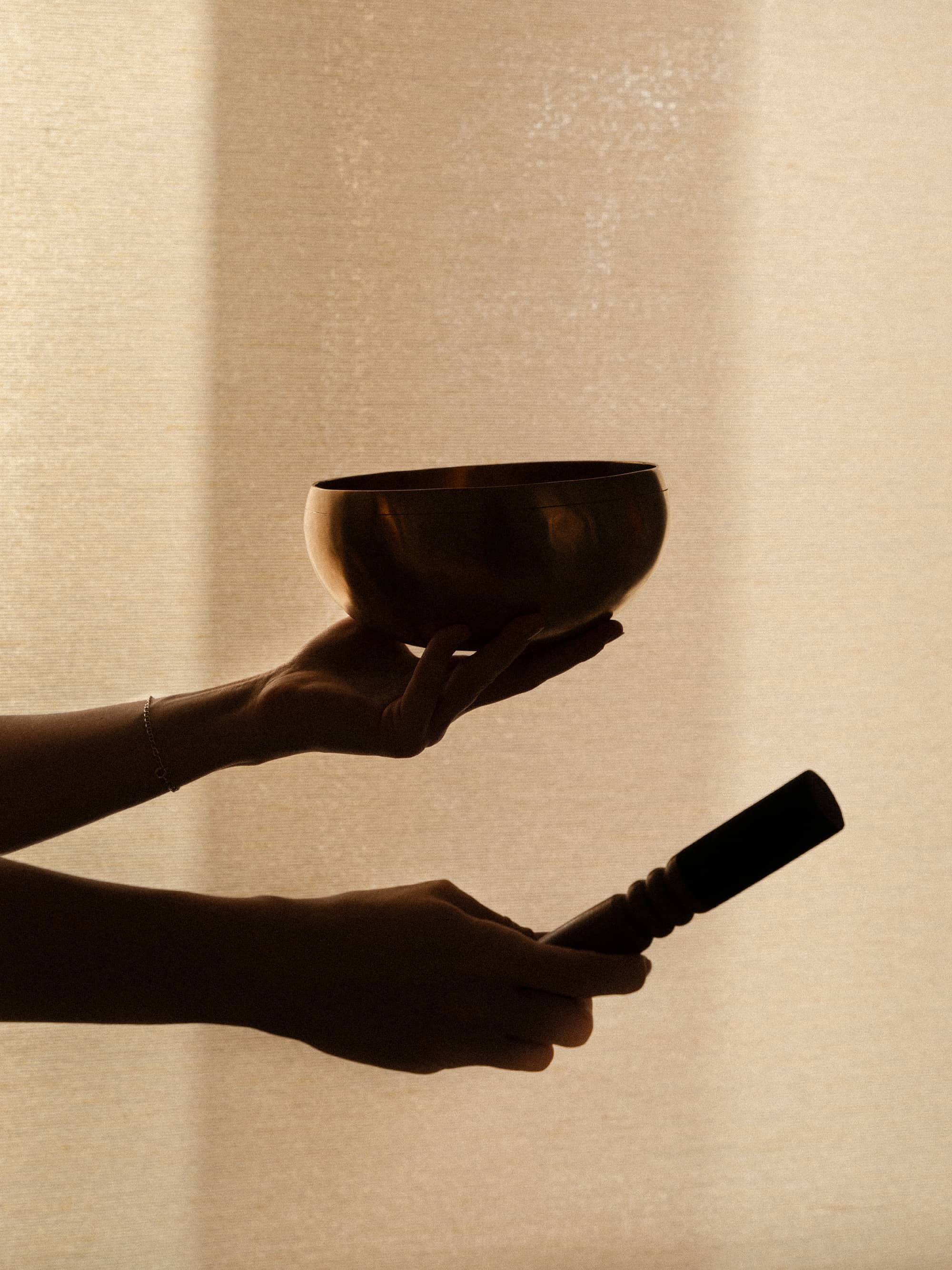 singing bowl in hands with soft light and studio backdrop