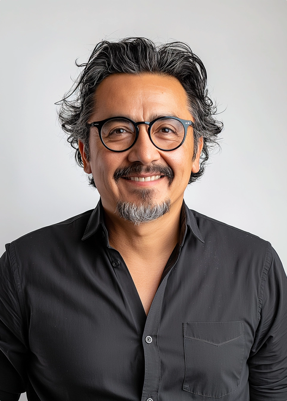 A smiling man wearing glasses and a shirt, exuding a friendly and approachable demeanor.