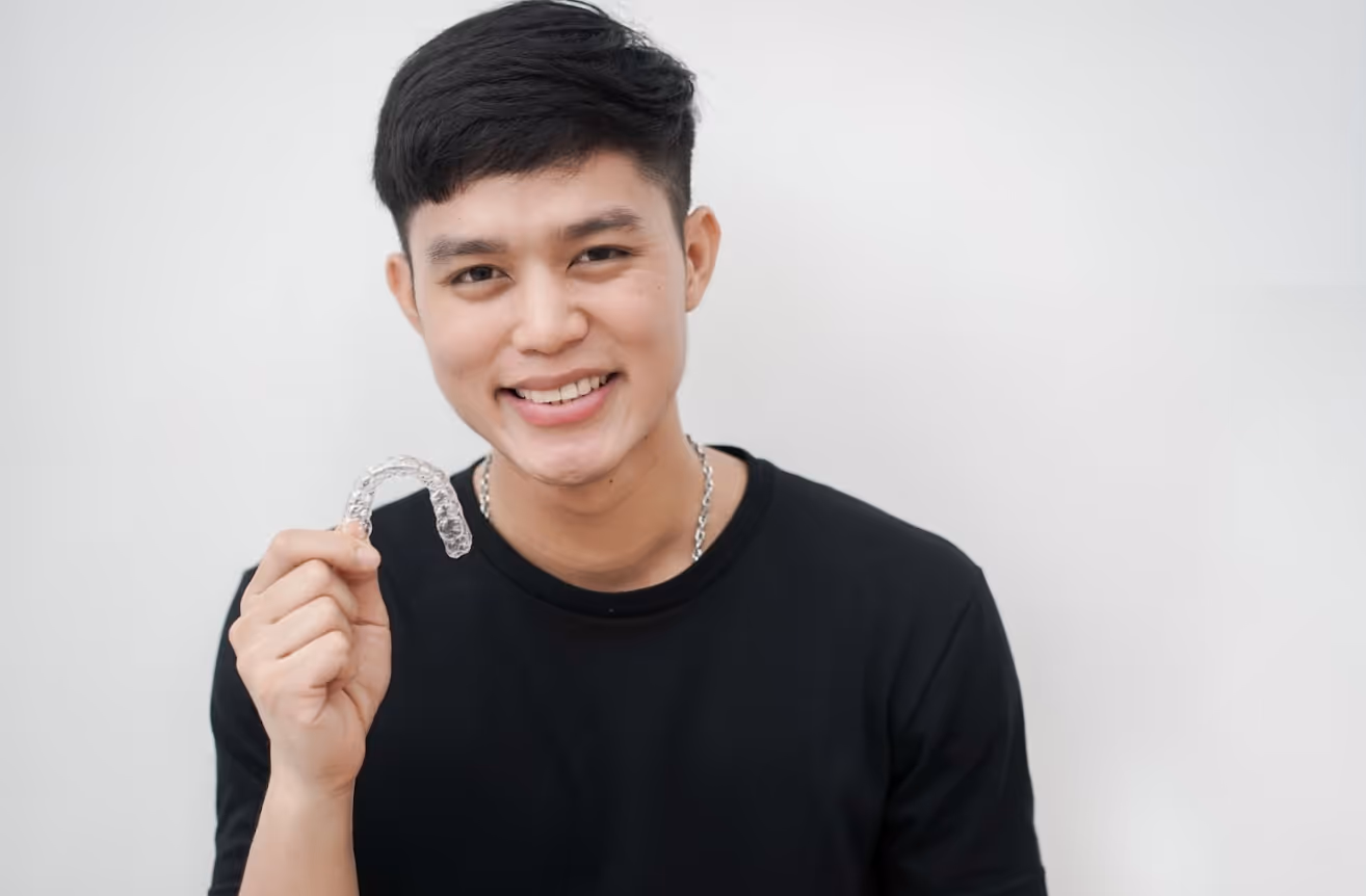 Man holding clear aligners excited to start treatment