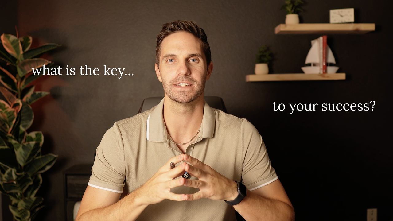 Man sitting at a desk speaking to the camera with the text “what is the key… to your success?” displayed on both sides of him.