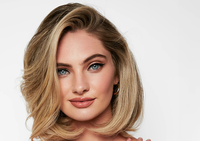 Woman with a glossy blonde bob after a salon service at Bartucci Beauty