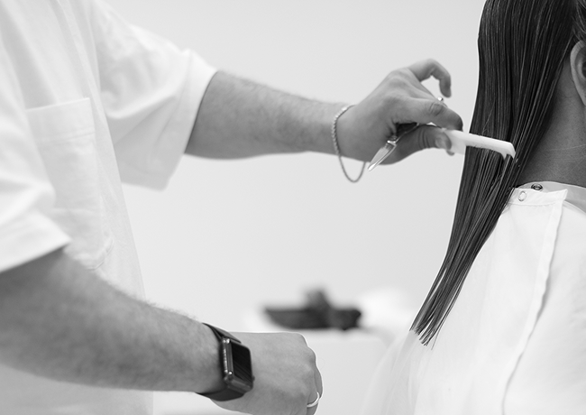 Bartucci Beauty stylist combing a client's long dark hair