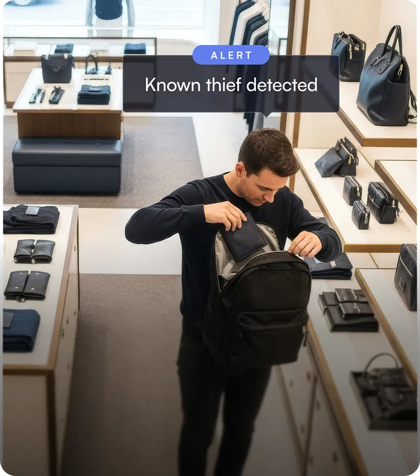 Man placing a wallet into a black backpack in a retail store with handbags and wallets on display, with an alert message saying 'Known thief detected'.