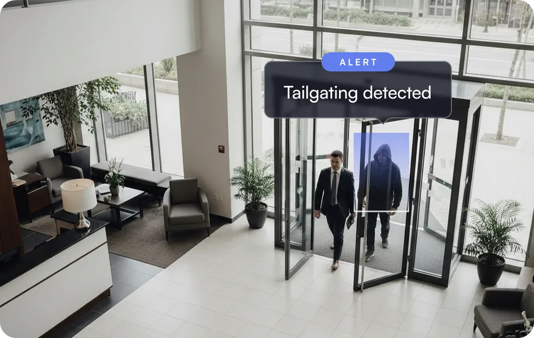 Security alert showing two men entering a building through revolving doors, with a notification highlighting tailgating detected on the man wearing a hoodie.