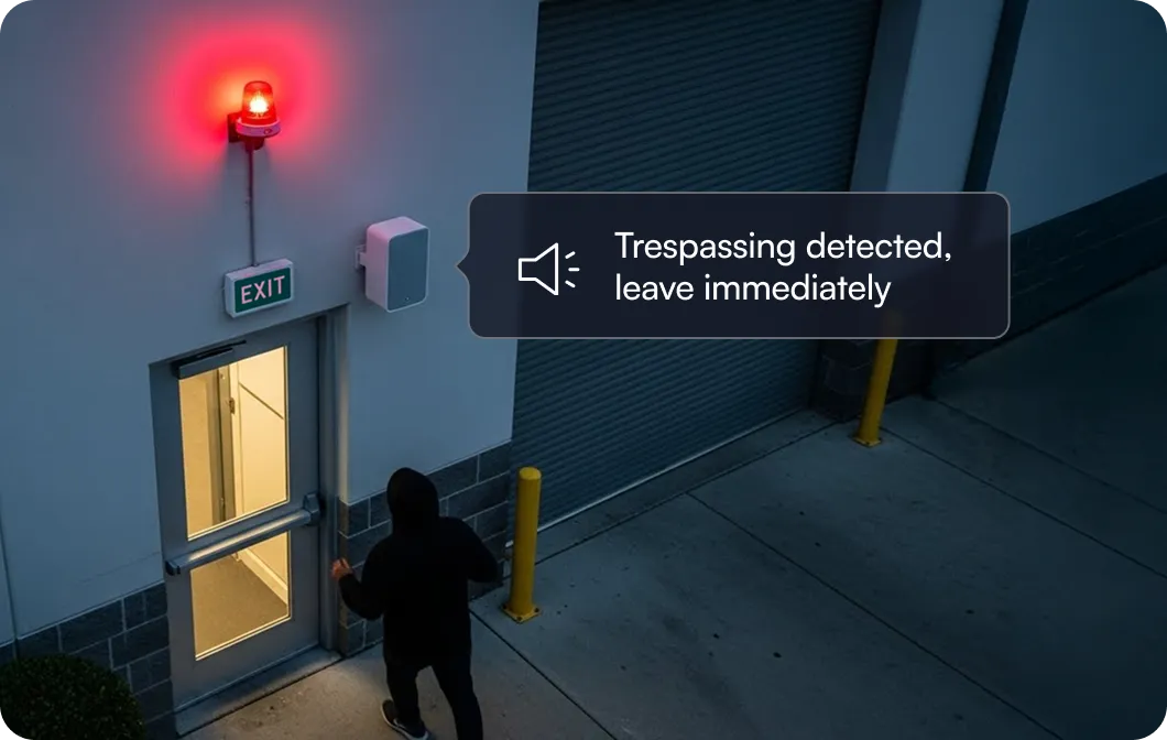 Person in black hoodie opening exit door under a red flashing alarm with message saying 'Trespassing detected, leave immediately'.