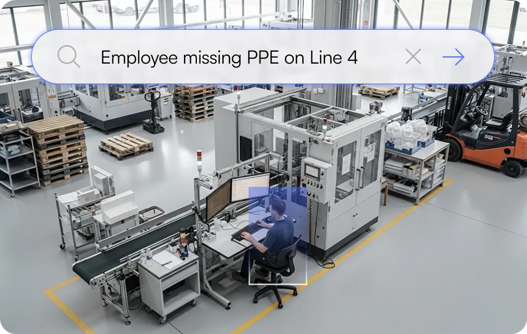 Worker sitting at a computer workstation next to industrial machinery in a factory setting, highlighted with a translucent box and overlaid text reading 'Employee missing PPE on Line 4'.