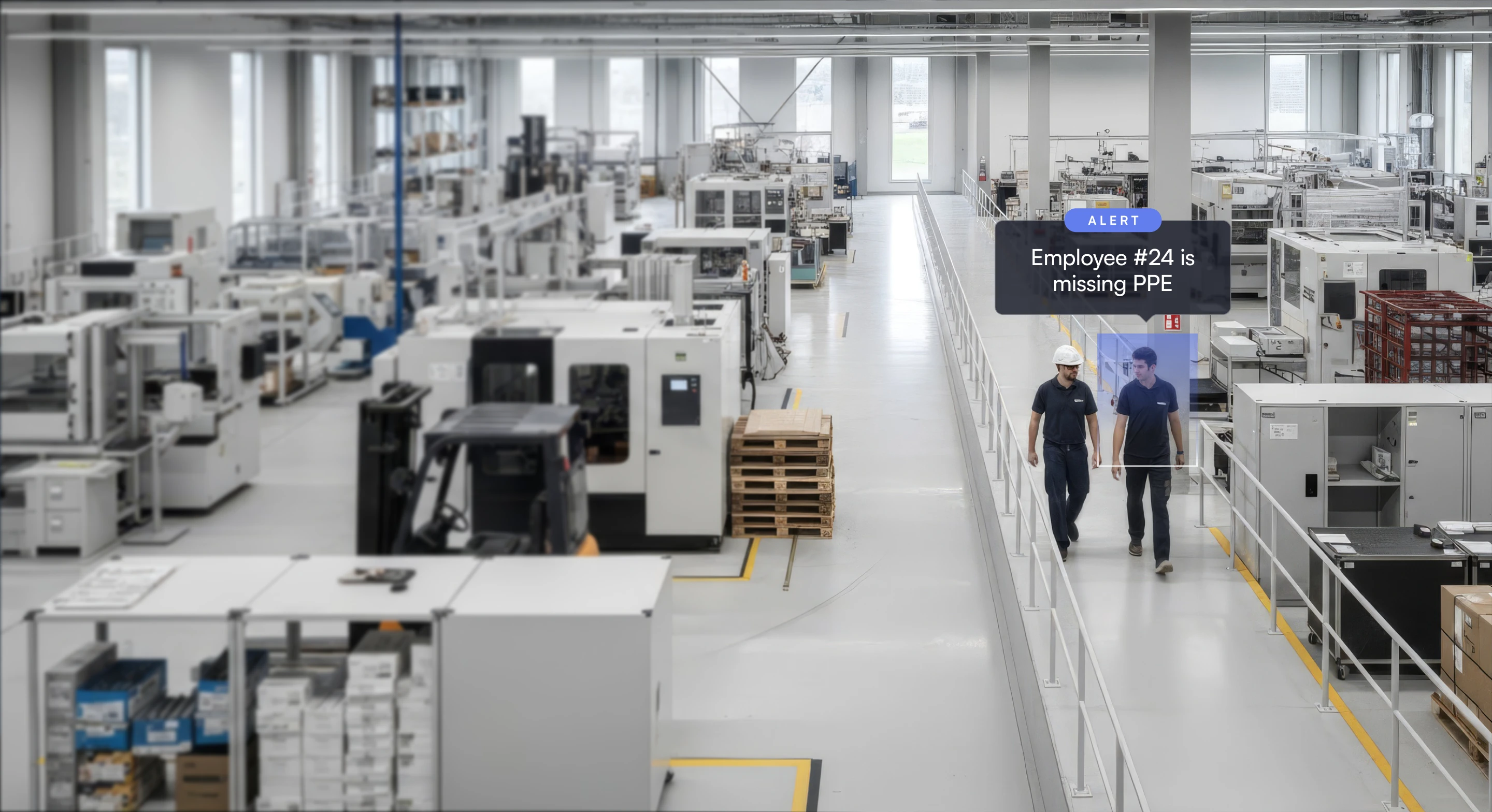 Two factory workers walking in a manufacturing plant aisle, one wearing a hard hat, with an alert indicating employee #24 is missing PPE.