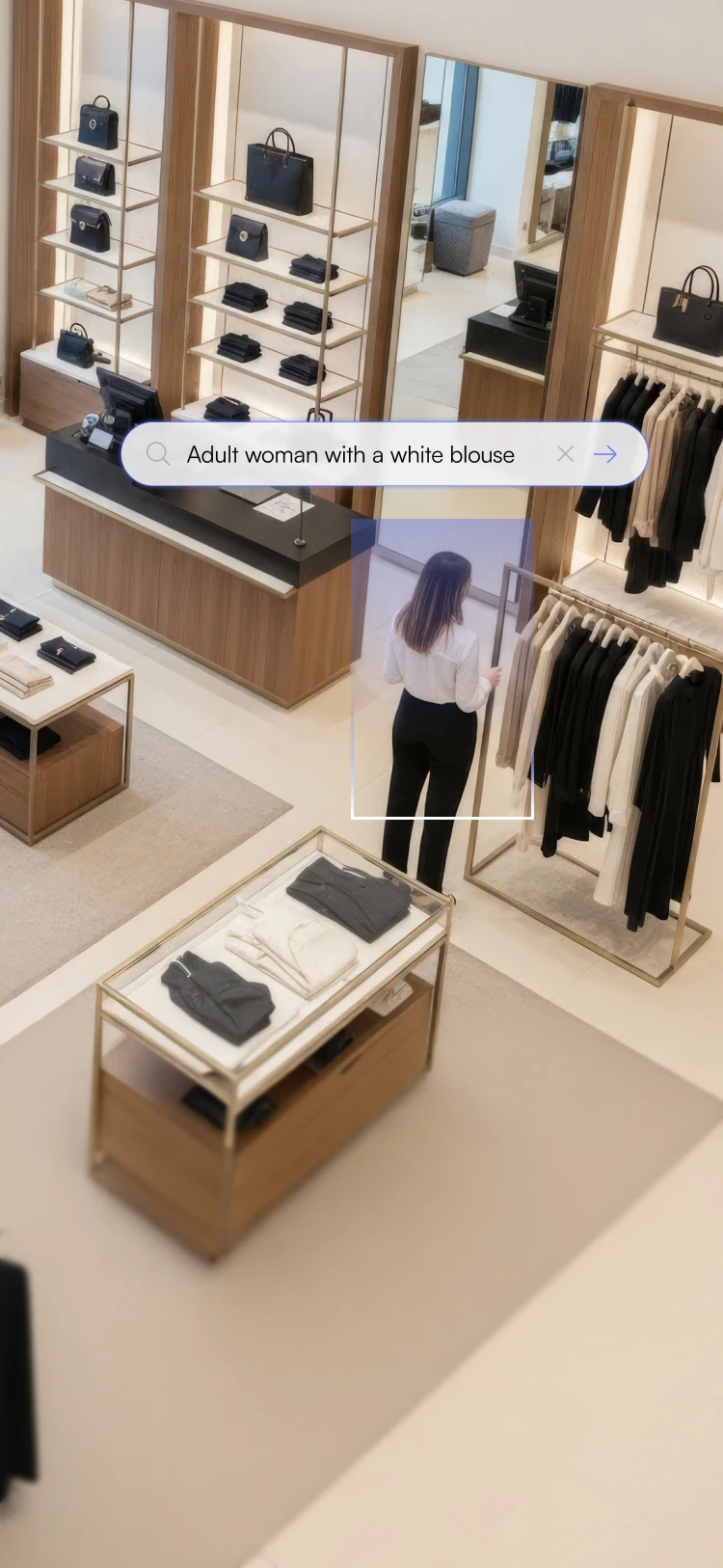 Woman in black pants and white blouse shopping for clothes in a modern store with light wood fixtures and neatly arranged black and white apparel.