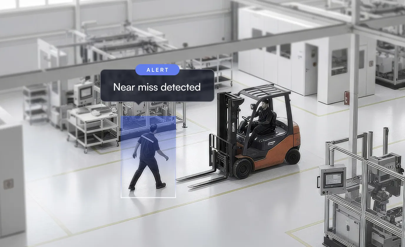 Worker walking near a forklift in a factory with an alert saying 'Near miss detected'.