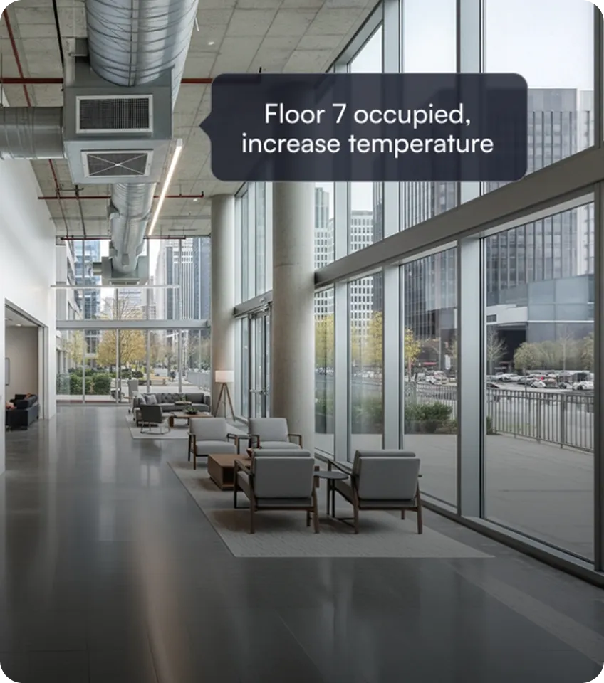Modern office lobby with gray chairs and tables by large windows showing city buildings, with overlay text reading 'Floor 7 occupied, increase temperature.'