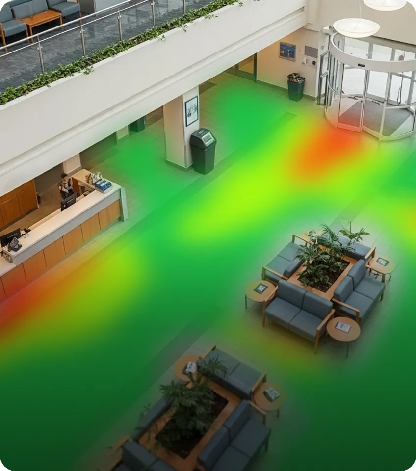 Lobby area with seating arrangements, plants, a reception desk with staff, and a revolving glass door entrance, overlaid with a heatmap highlighting foot traffic patterns.