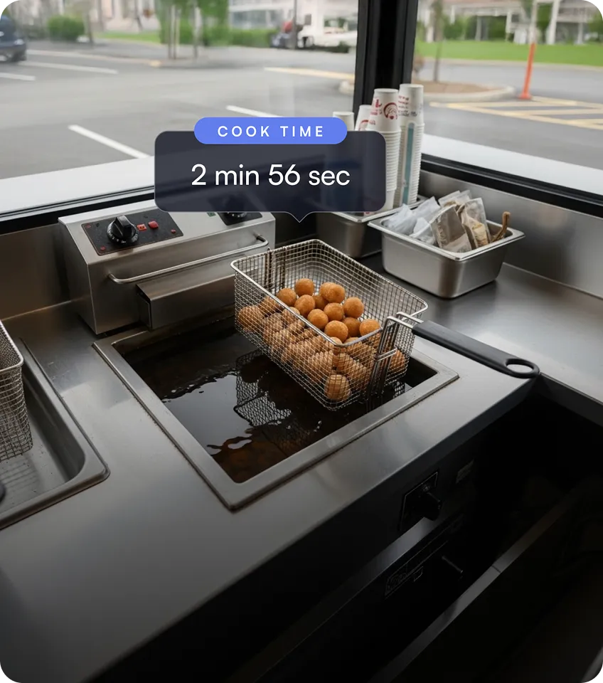 Deep fryer basket filled with round fried snacks cooking in hot oil with a cook time overlay showing 2 min 56 sec.