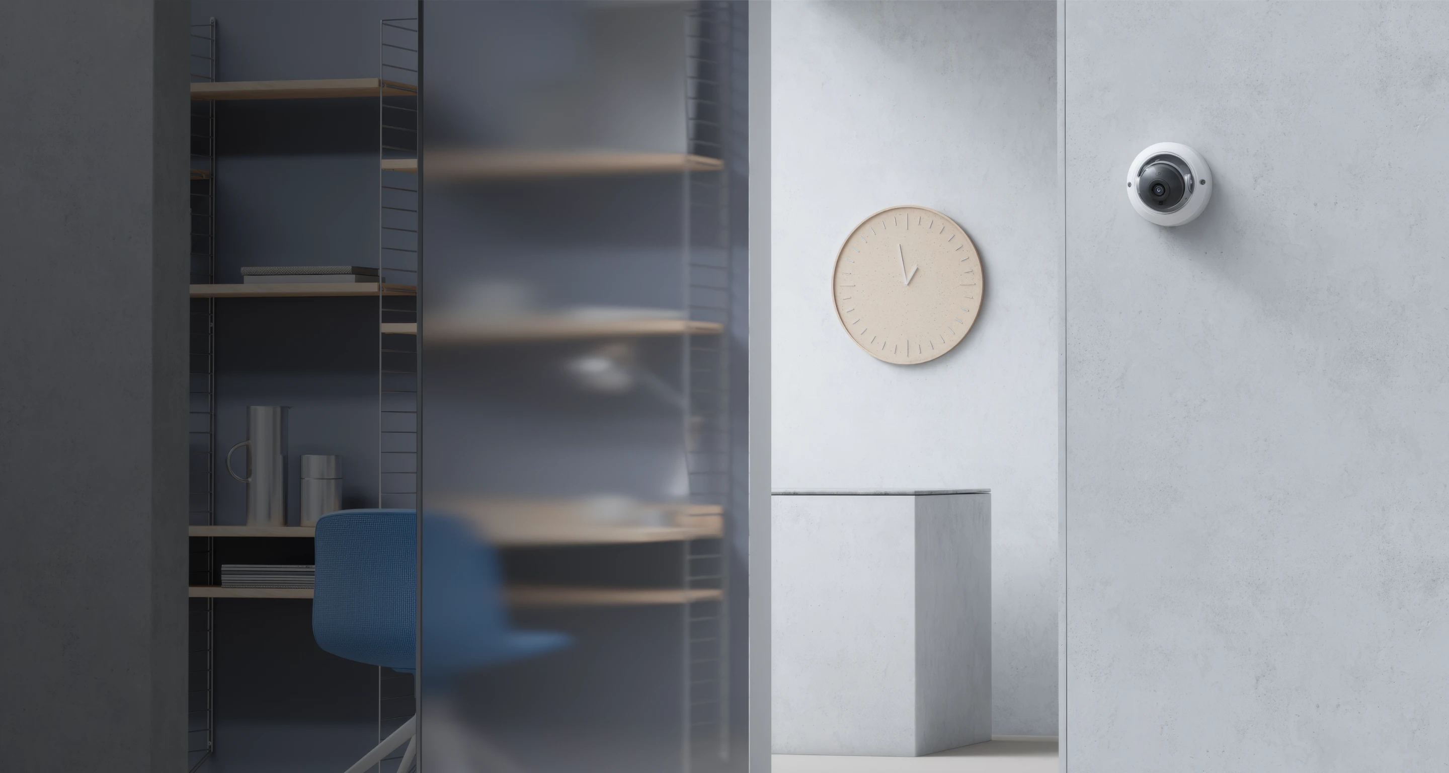 Modern office corner with blue chair, shelves, beige wall clock, and a security camera.