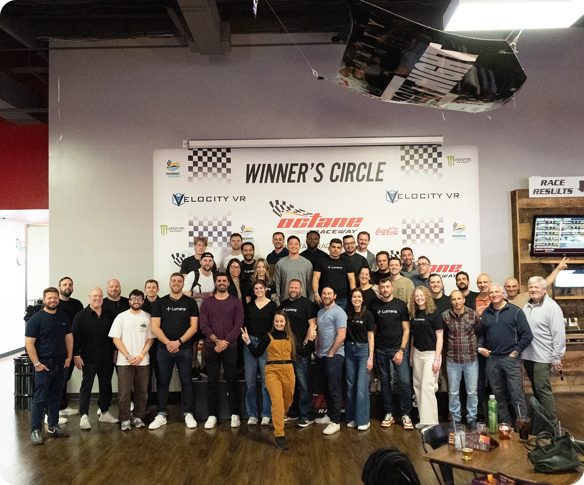 Group of people posing in front of a Winner's Circle banner at Octane Raceway.
