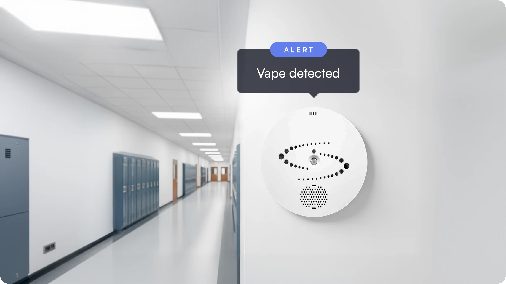 Smoke detector mounted on a white wall in a school hallway with lockers, displaying an alert message saying vape detected.