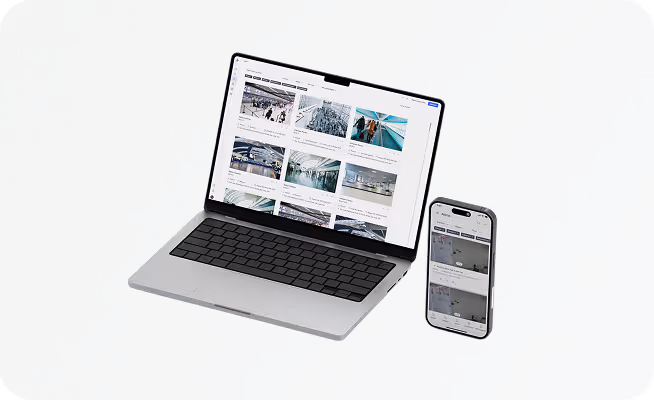 Laptop and smartphone on a gray surface displaying grids of images and text, suggesting a digital content or project management interface.