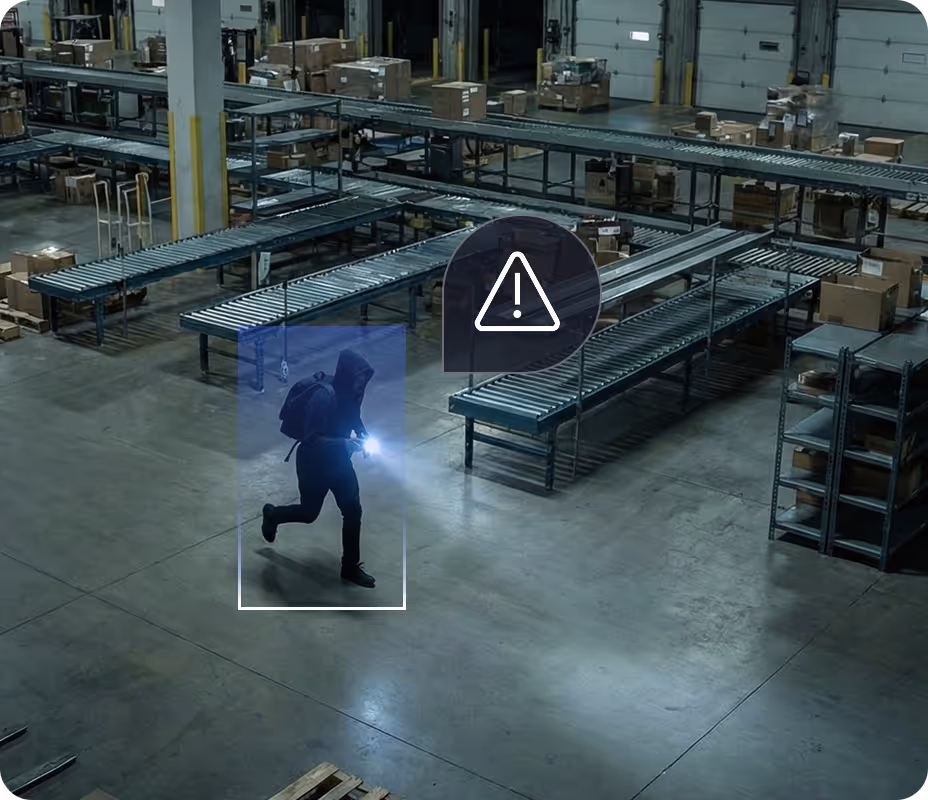 Person wearing a hood and backpack running inside a warehouse with a flashlight, highlighted by a detection box and a warning icon nearby.