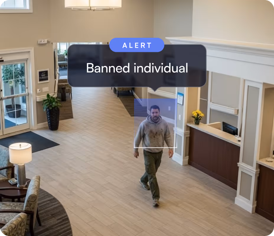 Man walking inside a lobby area with a digital alert label identifying him as a banned individual.