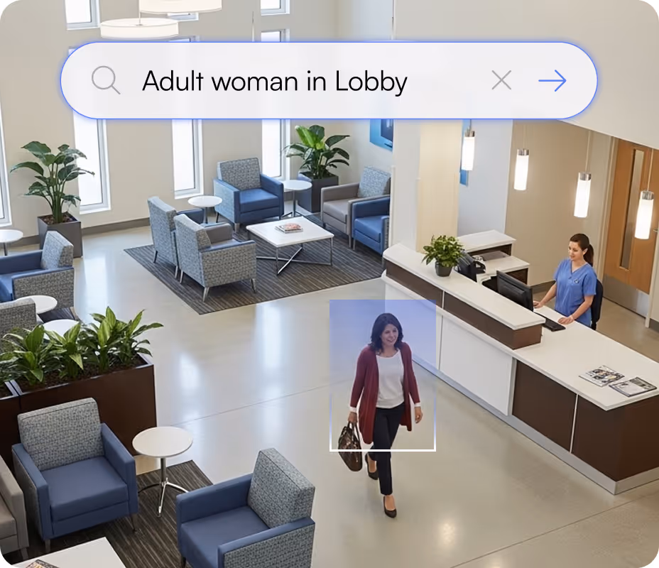 Adult woman walking through a modern lobby with seating and a receptionist at the front desk.