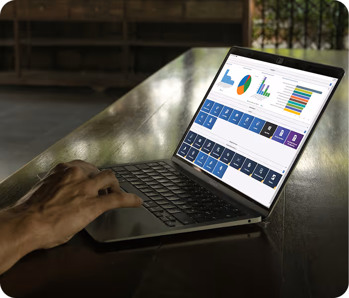 Person working on a laptop displaying colorful data charts and dashboard on screen.
