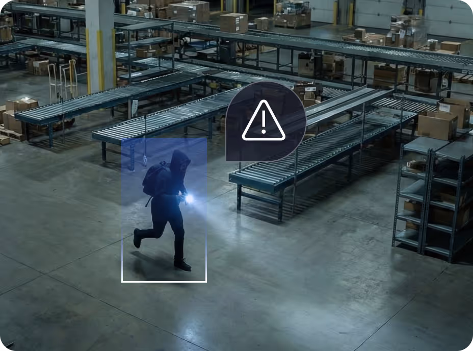 Person in dark clothes with backpack running inside warehouse, highlighted with warning icon overlay.