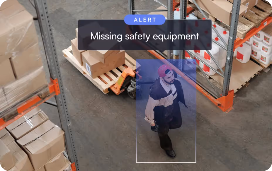 Warehouse worker walking without safety equipment, highlighted by an alert for missing safety gear.