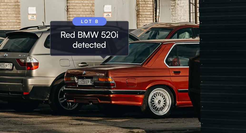 Red BMW 520i parked next to a silver SUV in a lot labeled Lot B with detection label.