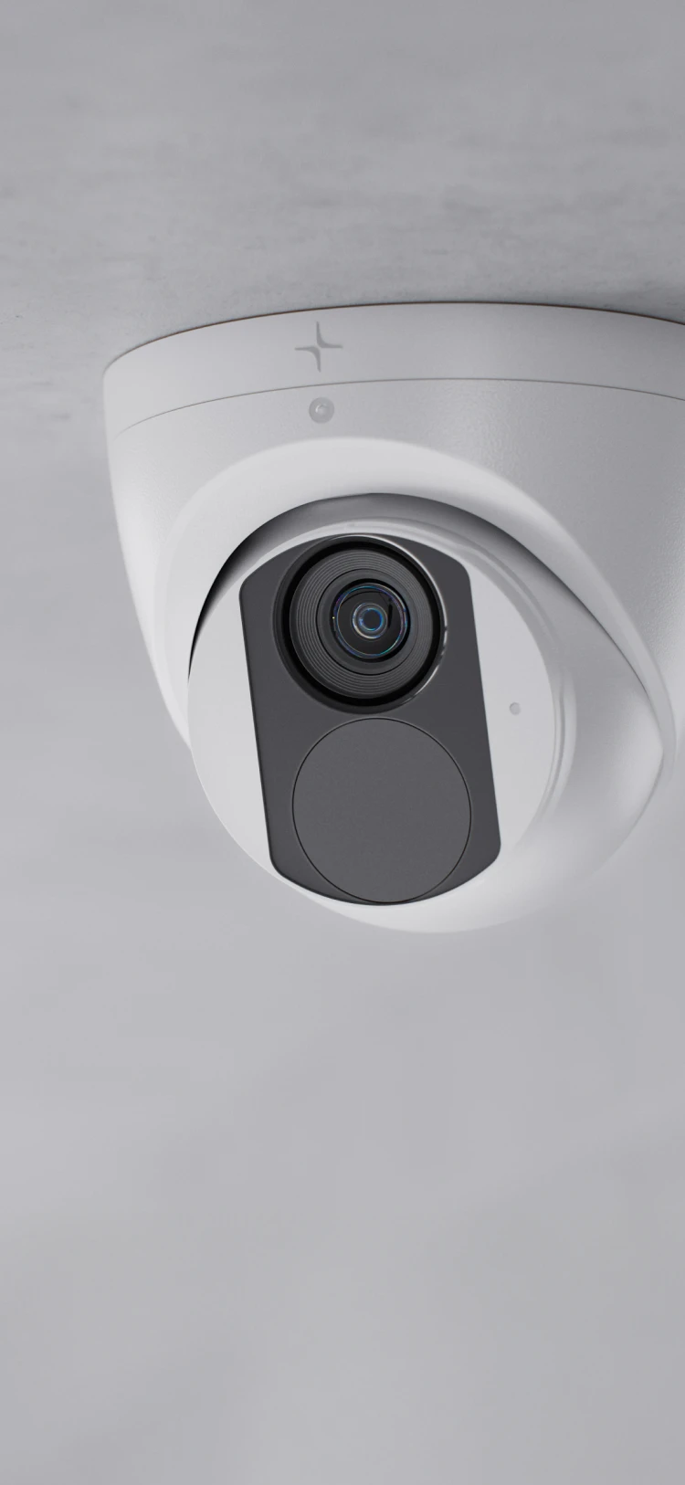 White dome security camera mounted on a gray ceiling with a black lens and sensor panel.